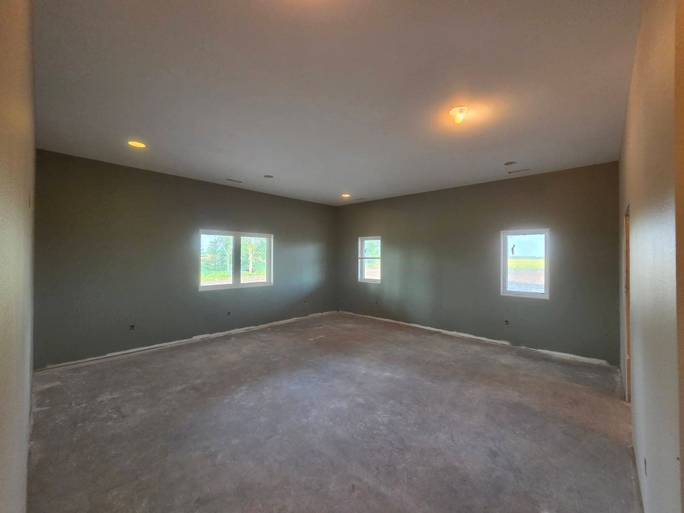 Painted room in a new-construction home with deep green walls and a white ceiling