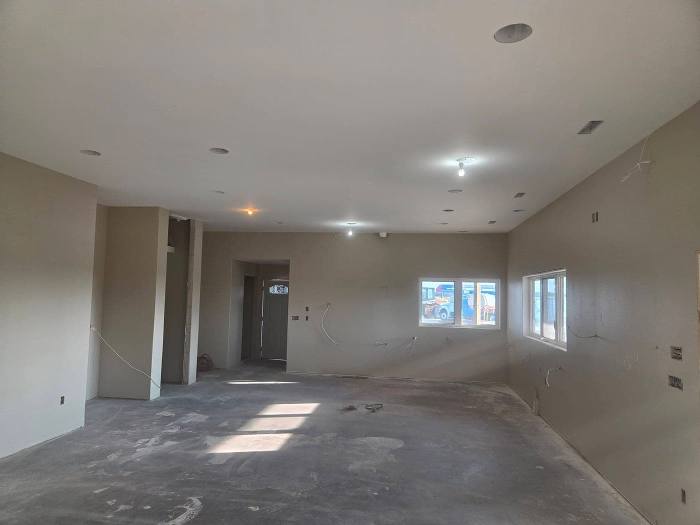 Open living area of a new-construction home with walls and ceiling freshly painted