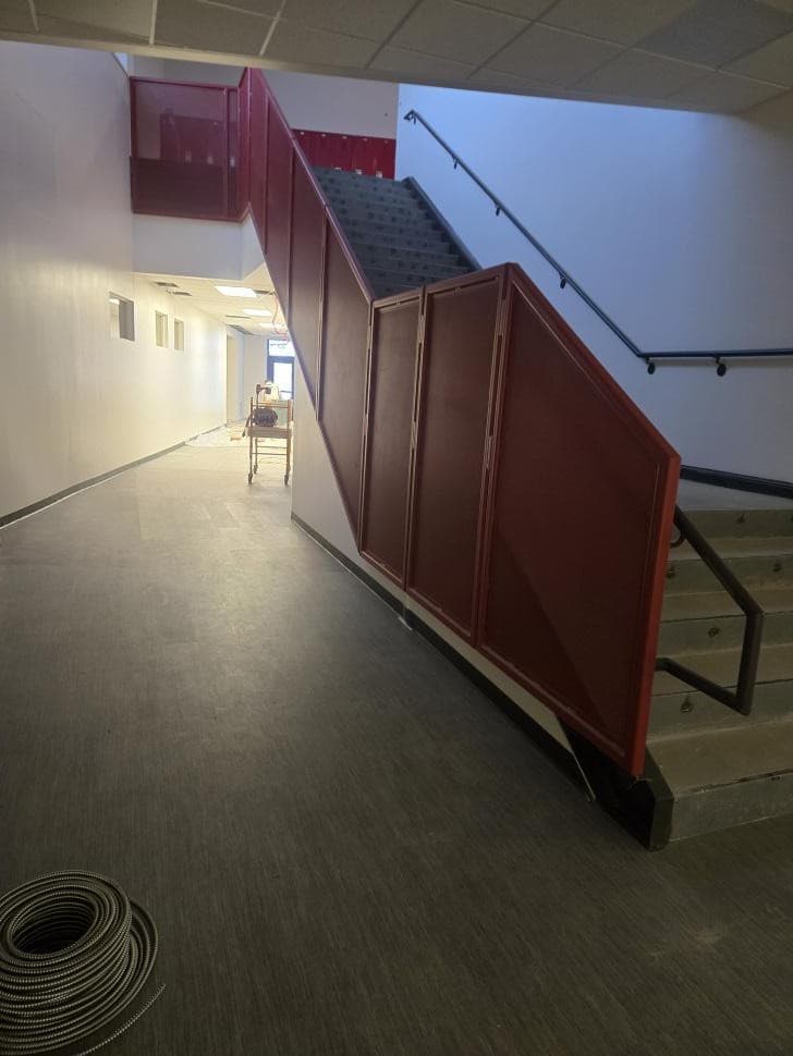 Interior stairwell and hallway repainted by Ultimate Painting, walls cut in clean against the railing and ceiling