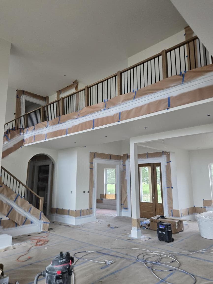 Two-story foyer and staircase fully masked and taped, ready for interior painting